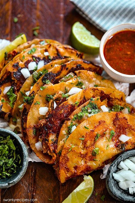 Birria Tacos In A Stack On A Wooden Cutting Board With Cilantro Onions