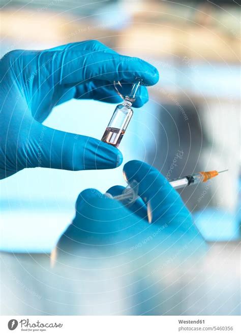 Scientist Holding A Vial Containing A Liquid In The Laboratory A