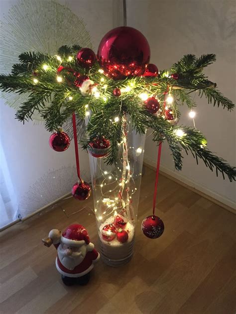 A Vase Filled With Ornaments And Lights On Top Of A Wooden Floor Next