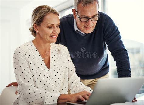 Connected To Things That Matter A Mature Couple Using A Laptop Together At Home Stock Photo