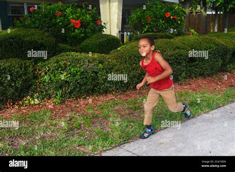 Young black boy running outside Stock Photo - Alamy