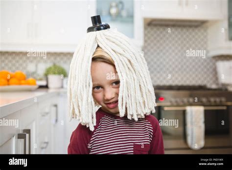 Happy Boy With Mop On Head In Kitchen Stock Photo Alamy