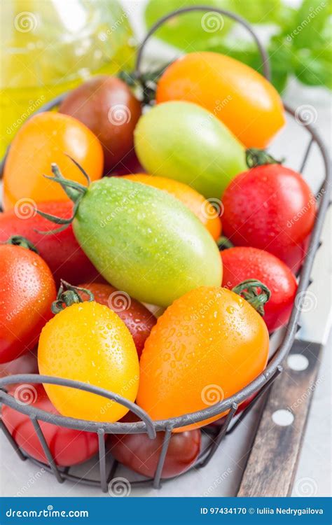 Small Colorful Cherry Tomatoes In Metal Basket Vertical Stock Photo