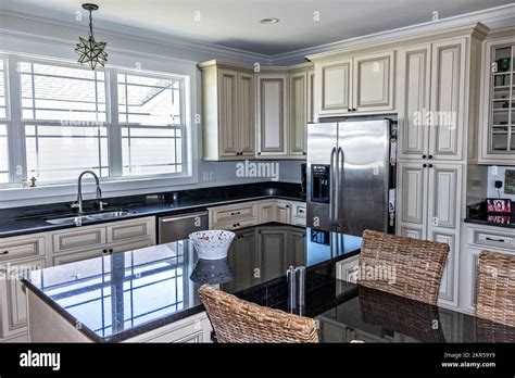 A Cream Colored New Construction Kitchen With Black Granite Countertops