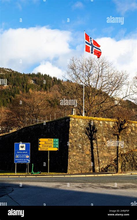 Norwegian National Flag In The Wind At Bergenhus Fort In The Port Of