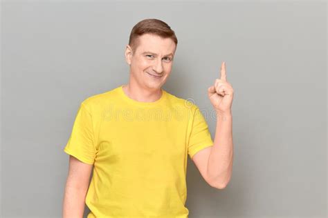 Portrait Of Happy Cheerful Mature Man Raising Index Finger And Smiling