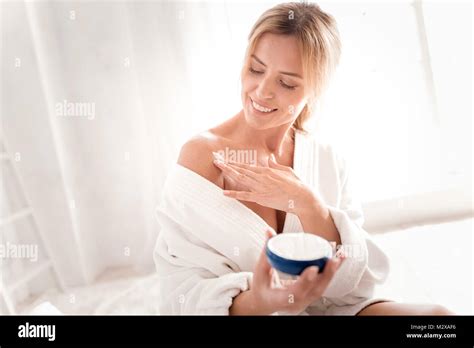 Cheerful Delighted Woman Applying Body Cream Stock Photo Alamy