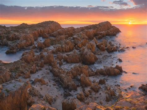 Um P R Do Sol Sobre O Oceano Pedras E O P R Do Sol Foto Premium