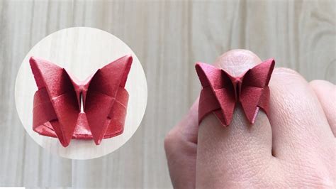 An Origami Bow Ring Is Shown In The Process Of Being Made With Red Paper