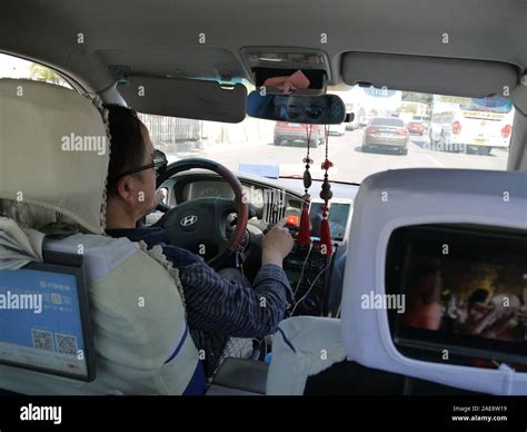 A taxi driver in Beijing, China and screens for advertisement inside ...