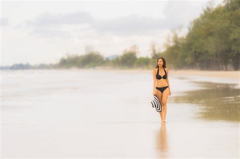 Bikini asiático joven hermoso del desgaste de mujer del retrato en el océano del mar de la playa