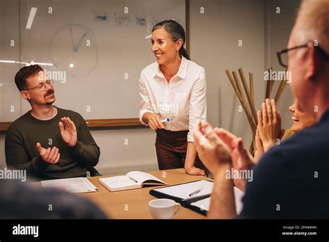 Mature Businesswoman Getting Applause From Team During Meeting