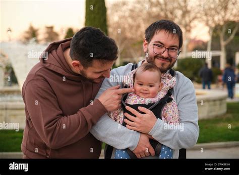 Adorable Gay Couple With Their 6 Month Old Baby In A Baby Carrier Stock Photo Alamy