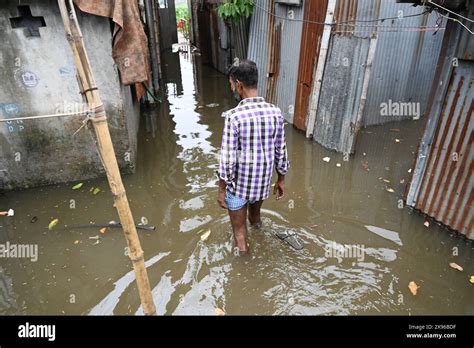 A Slum People Wades Through A Flooded Courtyard Following Heavy Rains