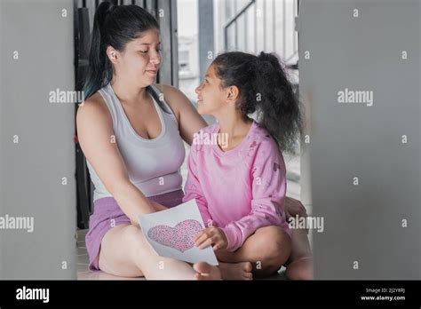 belle mère de latina avec sa fille brunette aux cheveux bouclés souriante et heureuse pour le