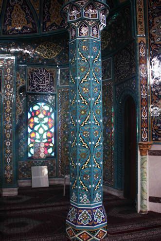 An Ornately Decorated Column In The Middle Of A Room With Stained Glass