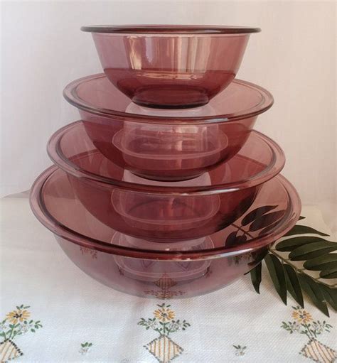 A Stack Of Pink Glass Bowls Sitting On Top Of A Table