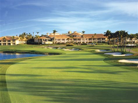 A Golf Course With Water And Palm Trees In The Background Surrounded