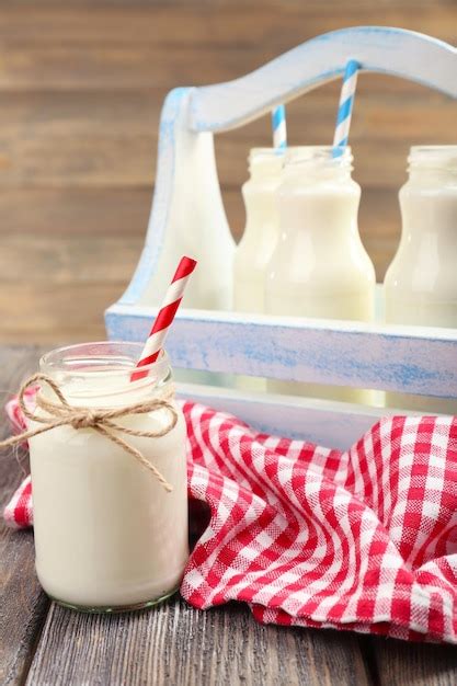 Premium Photo Milk In Bottles With Paper Straws On Table