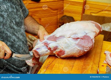 O Cozinheiro Chefe Que Corta A Placa De Madeira Da Carne De Porco Crua