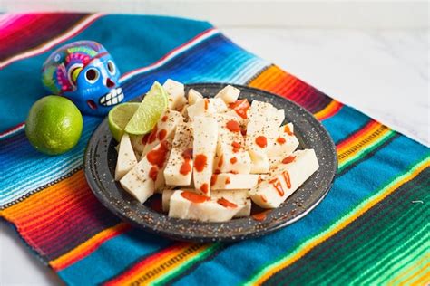 Fruta de jícama mexicana cortada con chile limón y chamoy Foto Premium