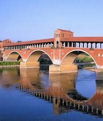 An Old Stone Bridge Spanning The Width Of A River