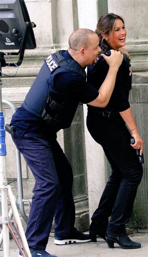 A Police Officer Standing Next To A Woman In Front Of A Camera On The