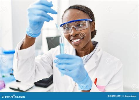 African American Woman Scientist Pouring Liquid On Test Tube At