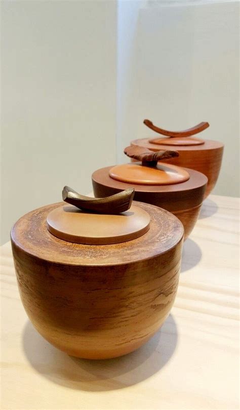 Three Wooden Bowls Sitting On Top Of A Table