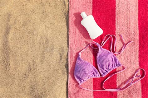 Toalla De Playa Con Cubierta De Bikini Y Protector Solar Sobre La Arena