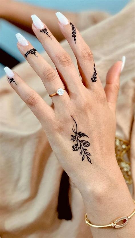 A Woman S Hand With Tattoos On Her Left Wrist And Two Fingers In The Middle