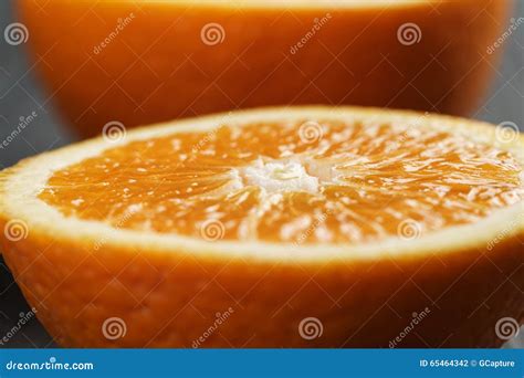 Dos Mitades De La Naranja Madura En La Tabla De Madera Foto De Archivo