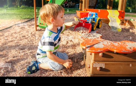 Portrait Of Little 3 Years Old Toddler Boy Sitting On The Playground