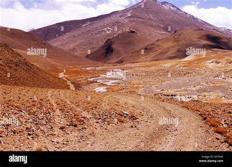 Long Dusty Winding Road Through Rough Mountain Terrain Landscape