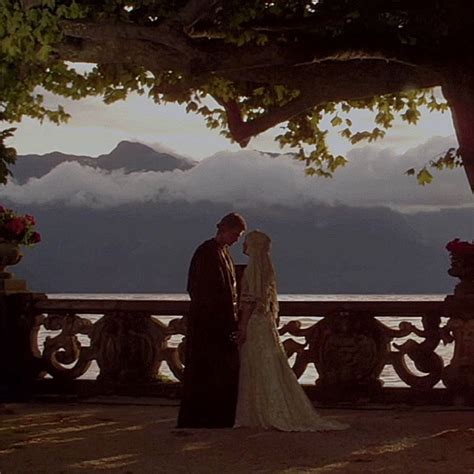 A Bride And Groom Standing Next To Each Other In Front Of A Tree With