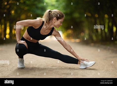 Active Blonde Middle Aged Woman Stretching At Public Park Stock Photo Alamy