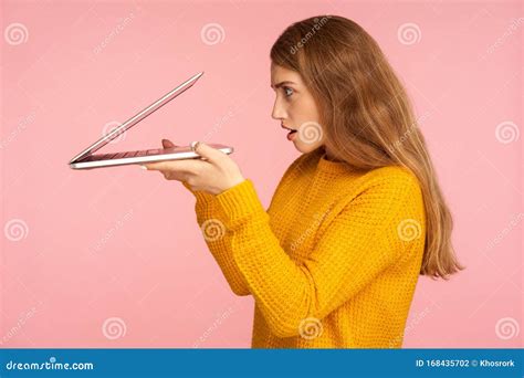 Portrait Of Curious Ginger Girl In Sweater Carefully Peeking Into Half