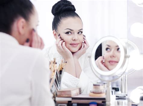 Portrait Of A Brunette Woman Putting On Make Up In Front Of The Mirror Stock Photo Image Of