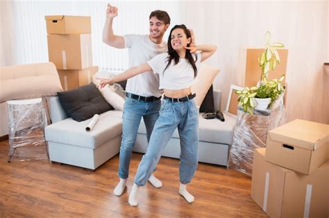 Premium Photo Overjoyed Young Couple Dance In Living Room Near