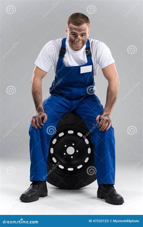 Smiling Man Sitting On Tire On Grey Background Stock Image Image Of