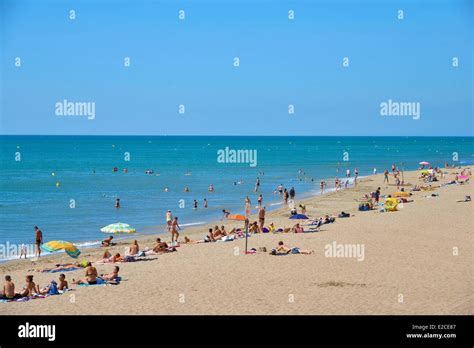 France, Herault, Serignan, Vacationers on a sandy beach in border of ...