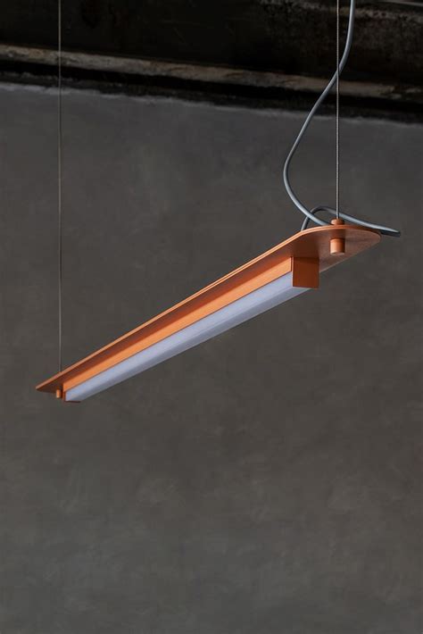 A Light Hanging From The Ceiling In A Room With Concrete Walls And Dark