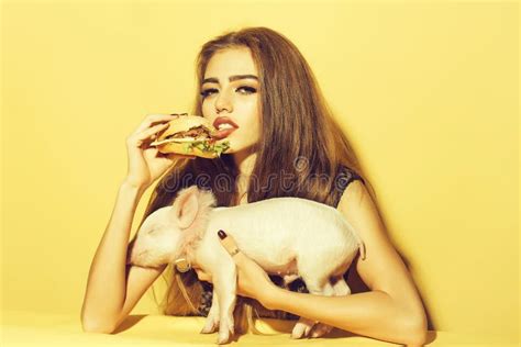 Muchacha Que Come La Hamburguesa Con El Cerdo Foto De Archivo Imagen