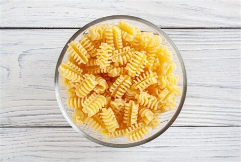 Premium Photo Uncooked Radiatori Pasta In Glass Bowl On White Wooden