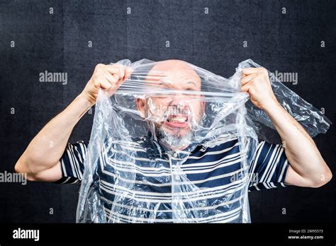 A Mature Man With Suffocating With Transparent Plastic Bag Flying Over