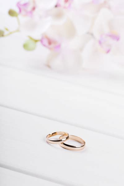 Ringe Der Goldenen Hochzeit Mit Blumen Auf Wei Em Lizenzfreies Foto