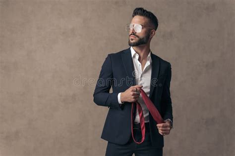 Cool Businessman Wearing Eyeglasses And Holding His Tie Stock Image