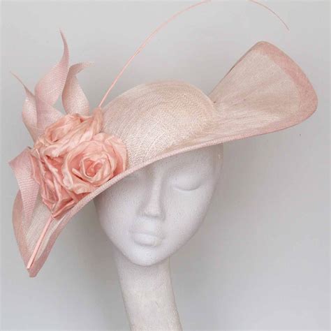 A White Mannequin Head Wearing A Pink Hat With Flowers On The Front And