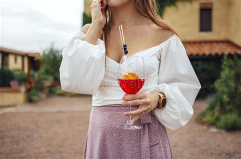 Close Up Of Female Hands Holding Glasses Of Acohol Cocktail With Fresh