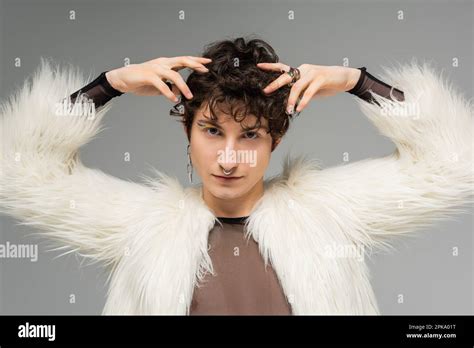 Brunette Nonbinary Model In Silver Accessories And White Faux Fur